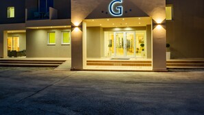 The exterior of the Gemini Hotel with a prominent 'G' sign, a covered entrance, and a well-lit facade. - CNic Gemini Hotel (Corfu)