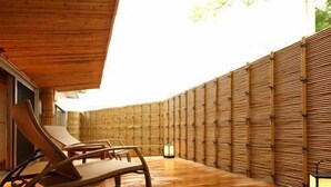 A wooden deck with a curved roof, a lounge chair, and a bamboo wall. - Matsumotoro (Shibukawa)