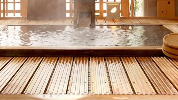A traditional Japanese onsen with a wooden floor, a hot spring bath, and a wooden partition with lattice design. - Matsumotoro (Shibukawa)