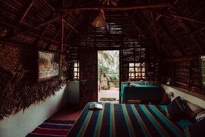 Um quarto com uma cama, uma mesa e vista para o exterior.