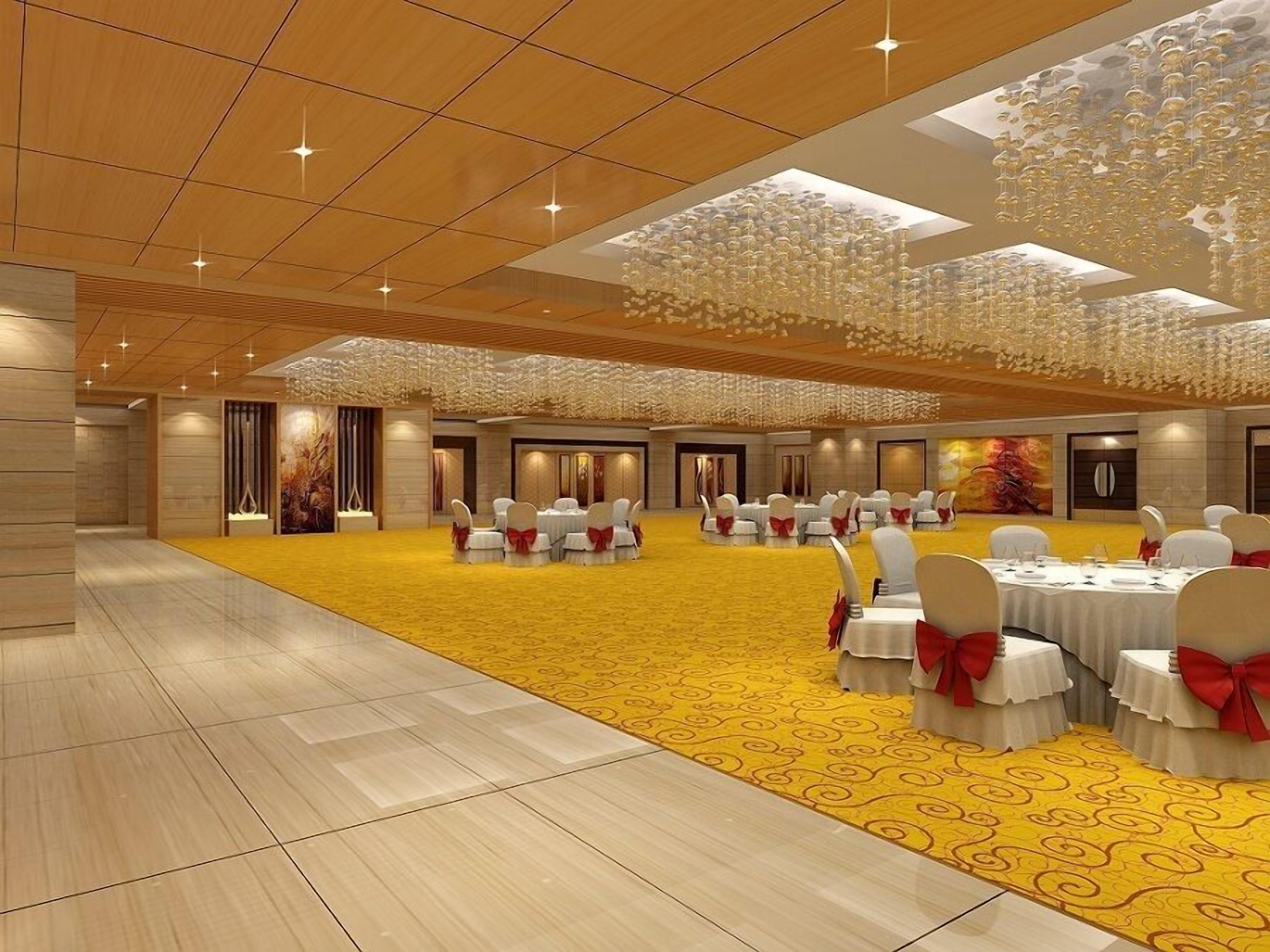 A spacious banquet hall with round tables and chairs, a yellow carpet, and a wooden ceiling.