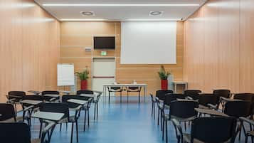 A conference room with a large screen, a whiteboard, and a projector.