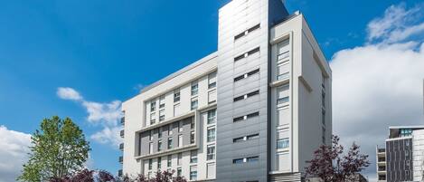 A modern multi-story building with a flat roof and a prominent corner section.
