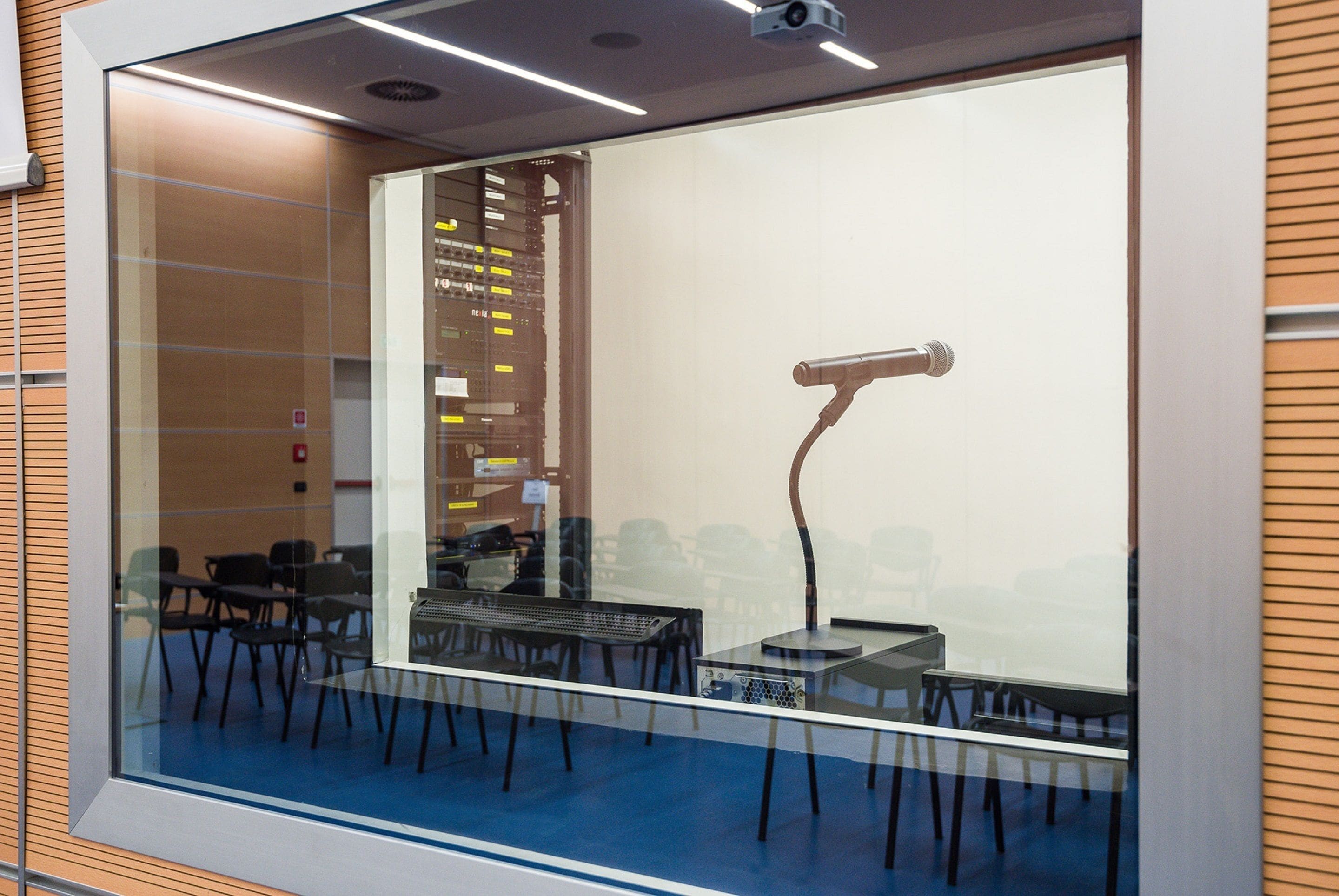 Een vergaderruimte met een grote glazen wand, een beamer en een whiteboard.