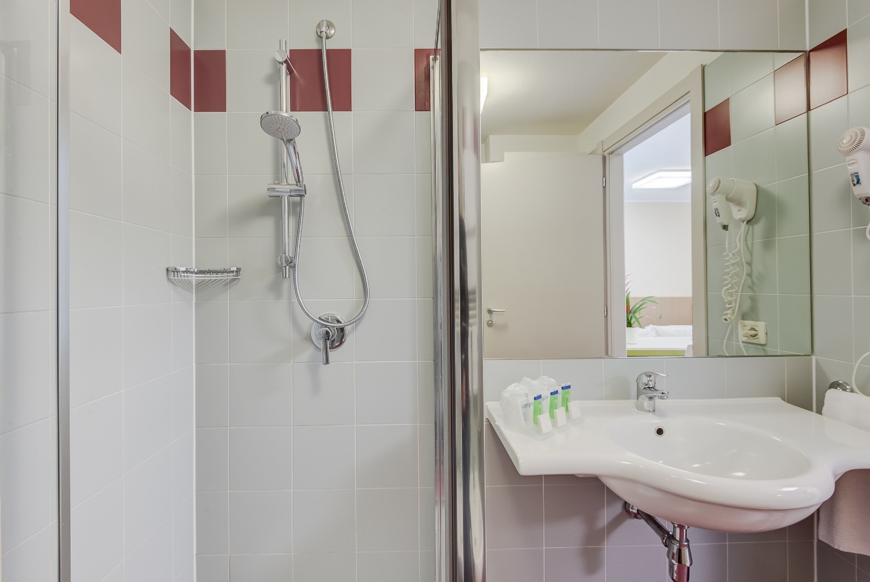 A bathroom with a shower, sink, and mirror.