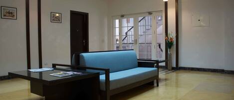 A room with a sofa, a small table, and a door leading to a staircase.