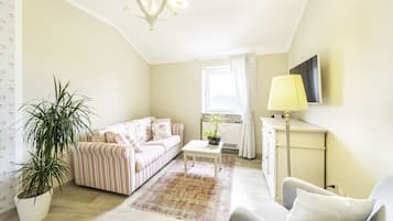 Suite Standard, 1 letto queen, bagno privato, piano elevato | Area soggiorno | TV a schermo piatto