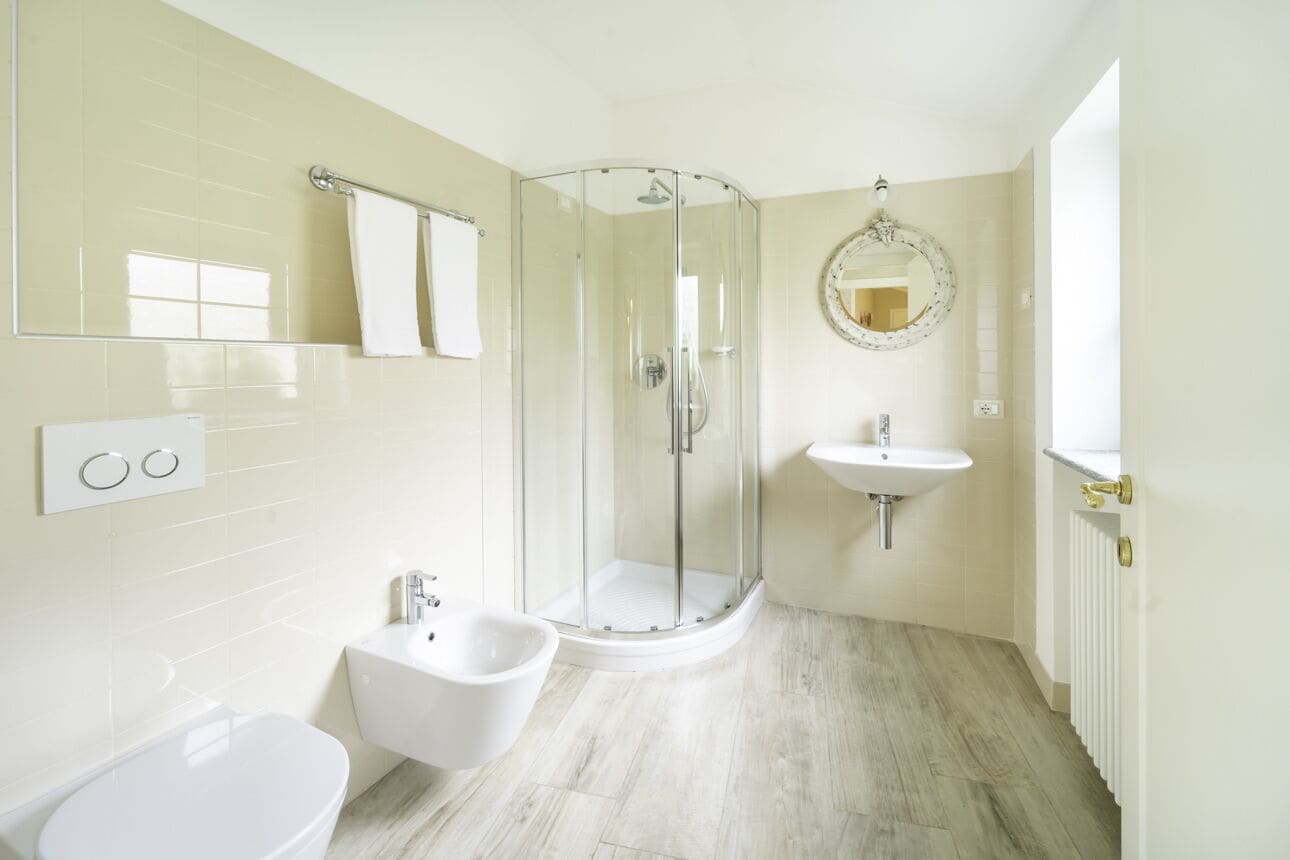 A modern bathroom with a glass-enclosed shower, a bidet, a sink, and a toilet.