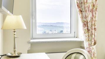 A room with a window, a lamp, a chair, and a bed.