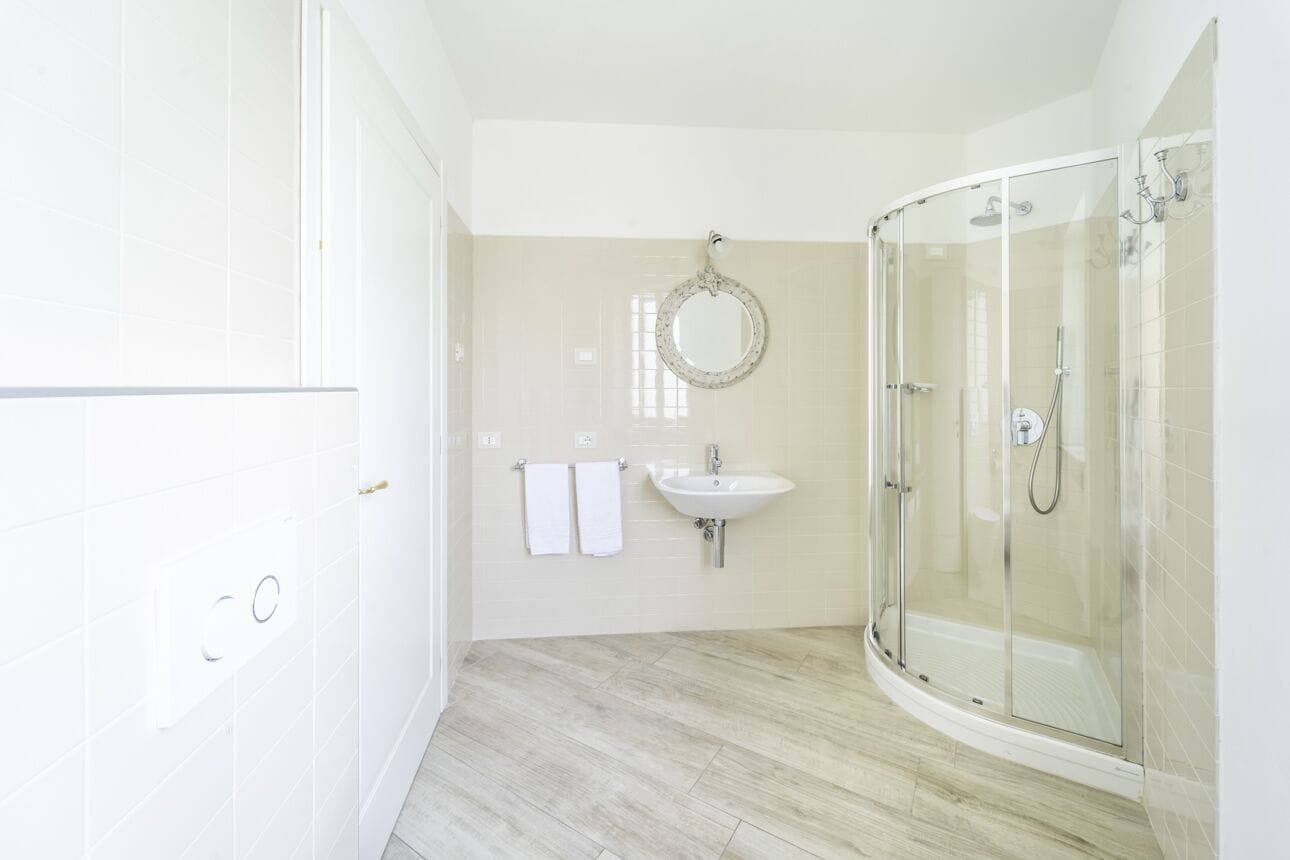 Een moderne badkamer met een douchecabine van glas, een wastafel en een spiegel.