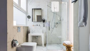 Un baño moderno con bañera, inodoro y zona de ducha.