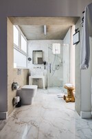Un baño moderno con bañera, inodoro y zona de ducha.