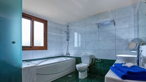 Un baño con bañera, inodoro y lavamanos.