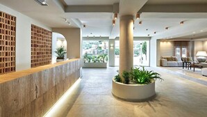 A spacious lobby with a reception desk, large pillars, and a seating area with a sofa and lamp. - Vasia Sea Retreat - Adults Only. (Agios Nikolaos)