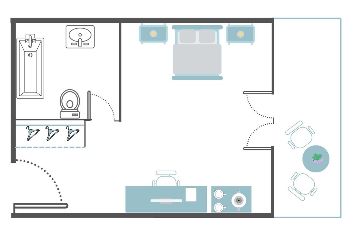 A hotel room layout with a bed, bedside table, lamp, and a small seating area with two chairs.