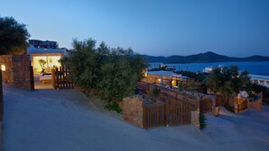 A coastal property with a stone entrance, wooden gates, and a view of the sea and mountains. - Elounda Eleon Villas (Agios Nikolaos)