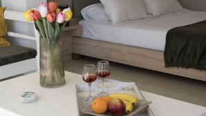 A neatly arranged breakfast tray with fruits and wine glasses on a white table in a hotel room. - Elounda Eleon Villas (Agios Nikolaos)