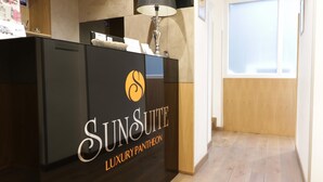 Un mostrador de recepción con un letrero que dice 'SUNSUITE LUXURY PANTHEON'.