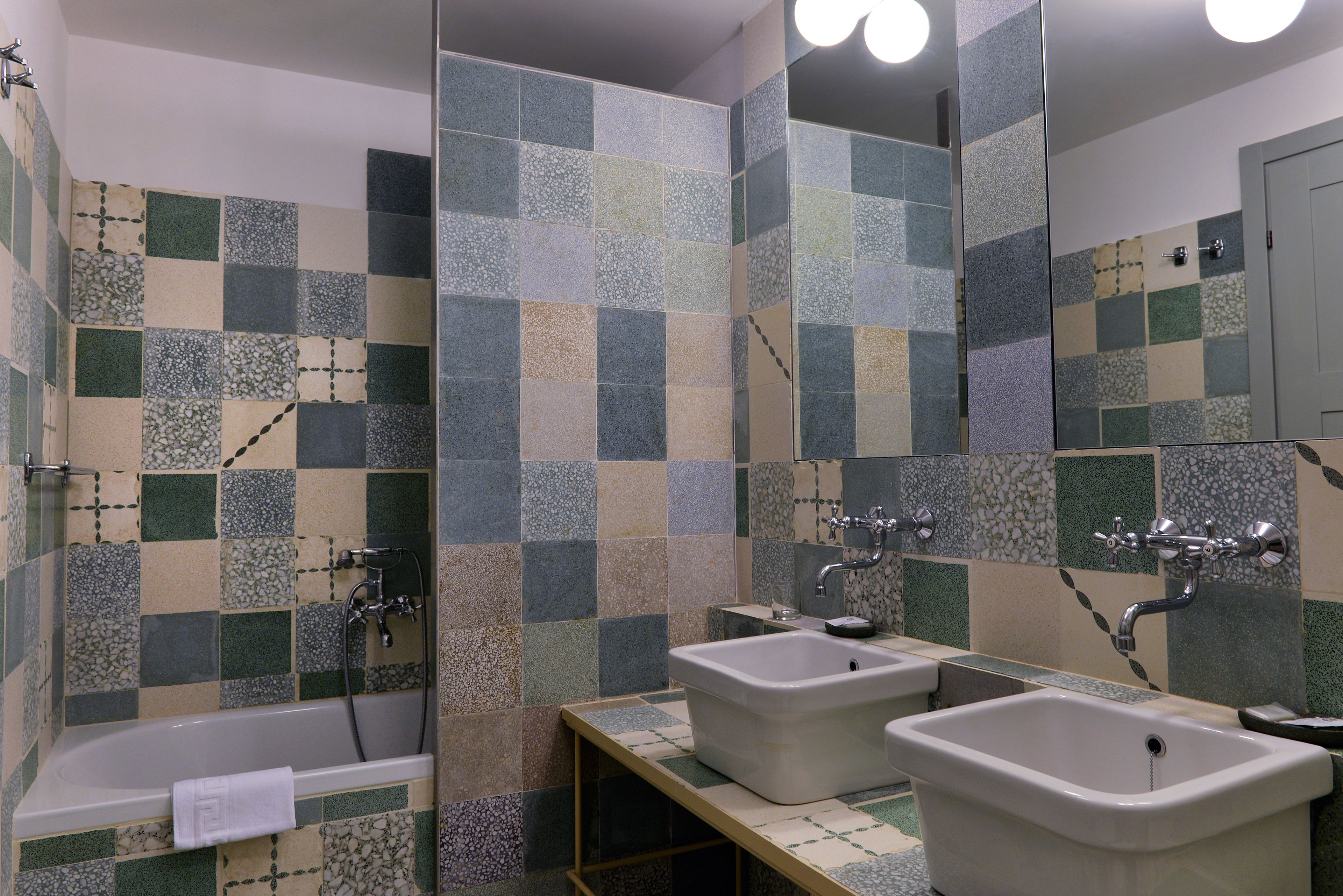 A bathroom with a bathtub, two sinks, and a mirror.