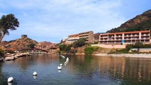 A riverside hotel with multiple buildings, a bridge, and buoys in the water.
