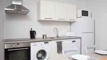Een moderne keuken met roestvrijstalen apparatuur, een vaatwasser en een magnetron.