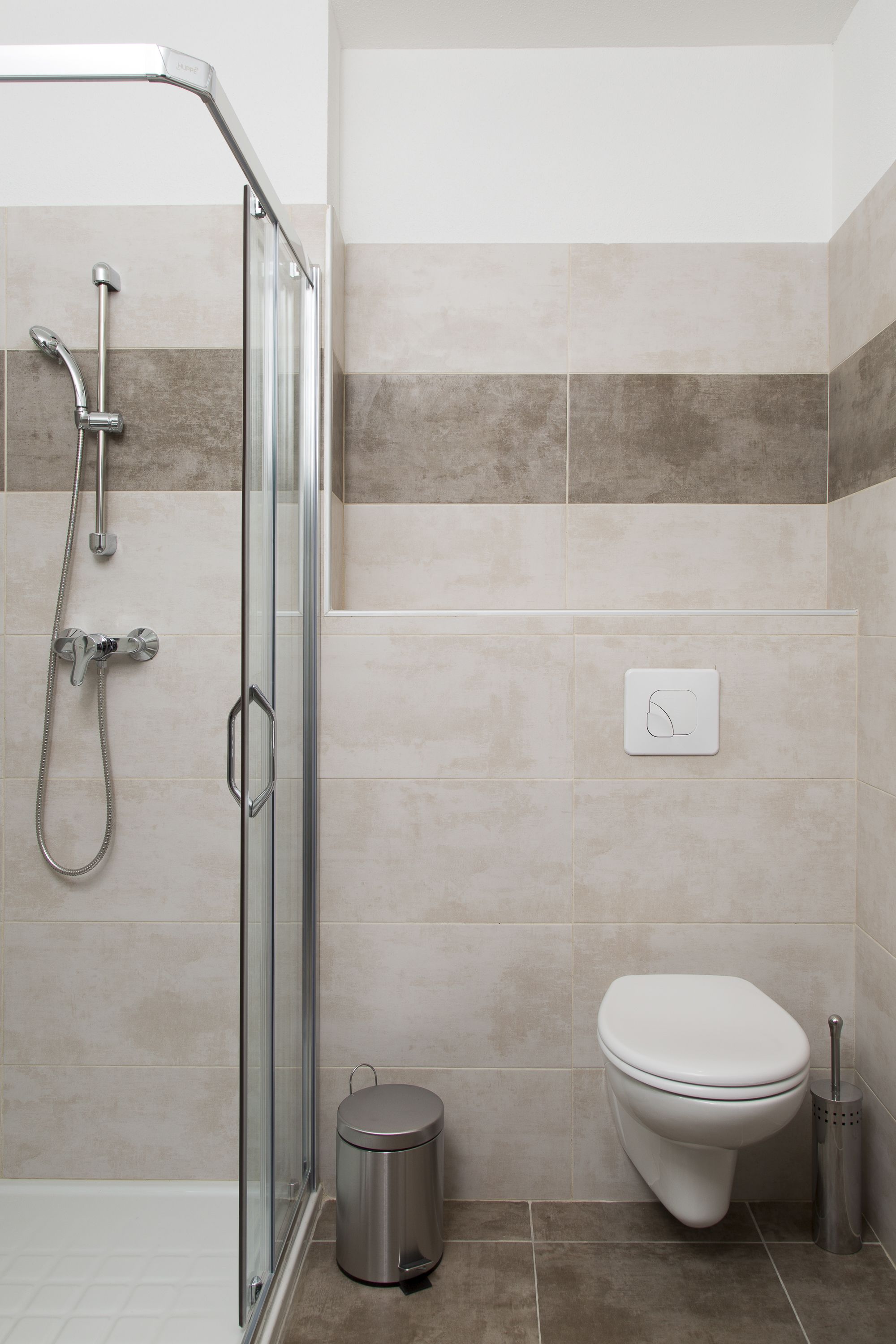 Une salle de bain moderne avec une douche à parois de verre, des toilettes et un bidet.