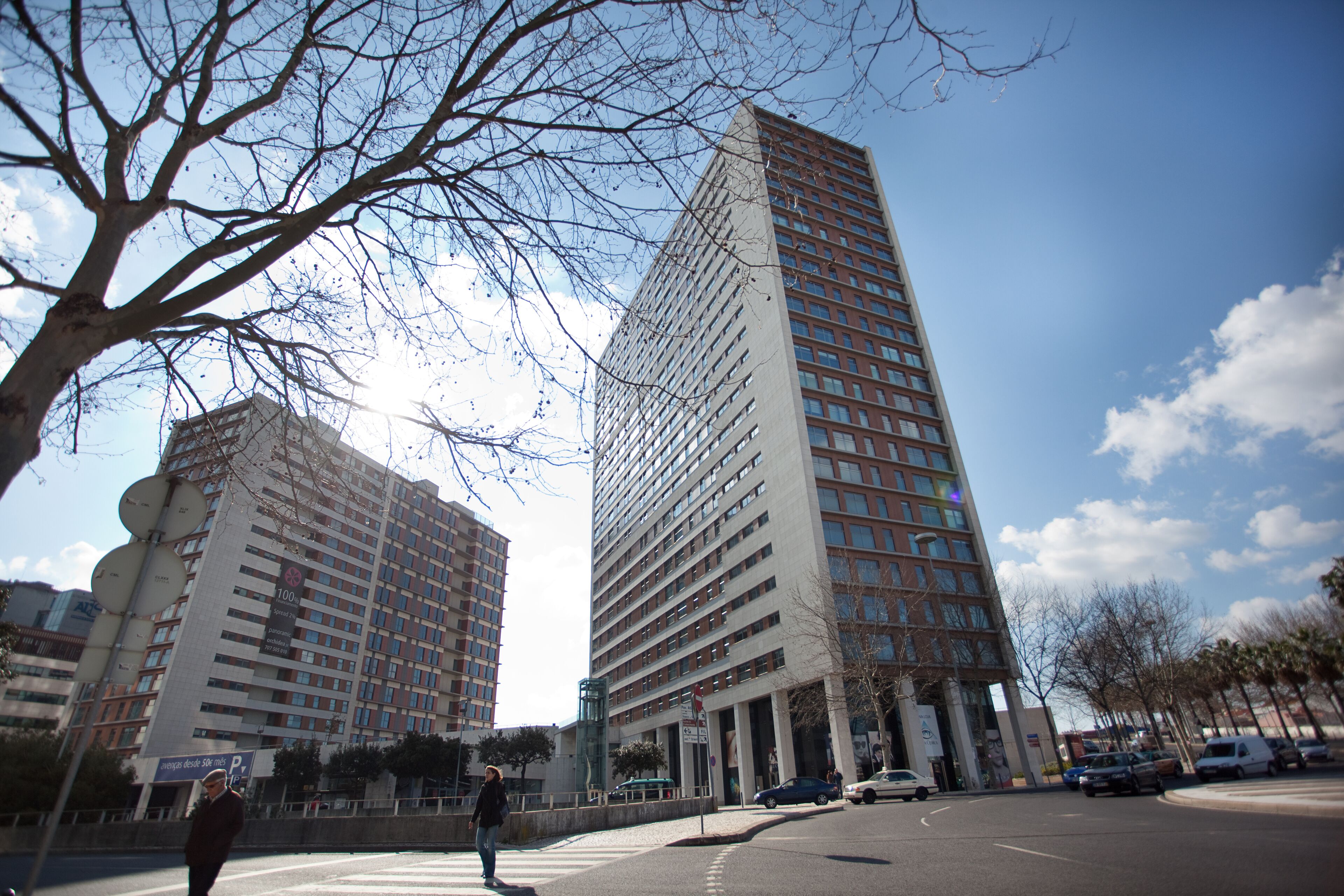 Un edificio alto con un diseño arquitectónico moderno, con varios pisos y una entrada destacada.