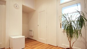 Una habitación con un radiador blanco, un electrodoméstico blanco y una planta en maceta.