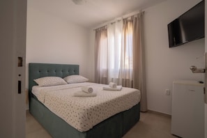 A hotel room with a bed, a television, and a refrigerator. - Apartments & Rooms Petra (Zadar)