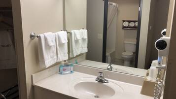 Un bagno con lavabo, specchio e asciugamani appesi.