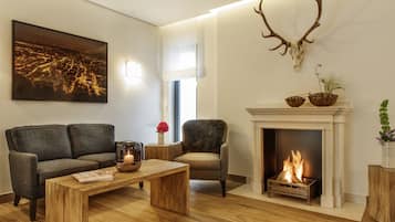 A living room with a fireplace, a sofa, a coffee table, and a mounted deer head.