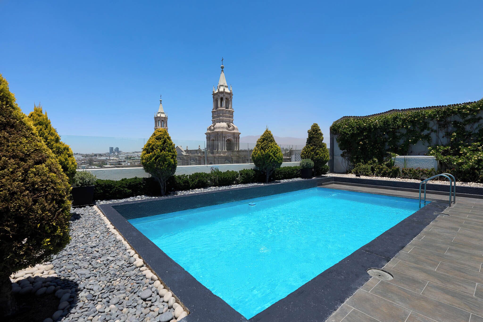 A swimming pool with a view of a historic building with two towers.