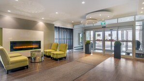 Un hall d’entrée moderne doté d’une cheminée, d’un espace salon et d’une entrée en verre.