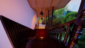 A staircase with a wooden handrail and a hanging light fixture. - Dream Mango Villa (Siem Reap)