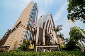 A high-rise building with a prominent entrance and a sign that reads "pullman." - Pullman Shishi Mattison (Quanzhou)