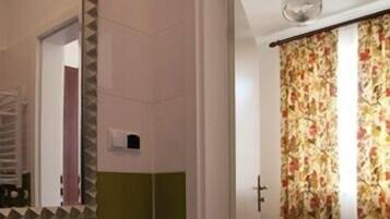 A bathroom with a white sink, mirror, and green-tiled walls.