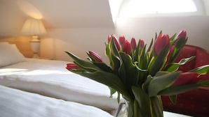 Habitación de hotel con cama, lámpara y ventana con luz natural.