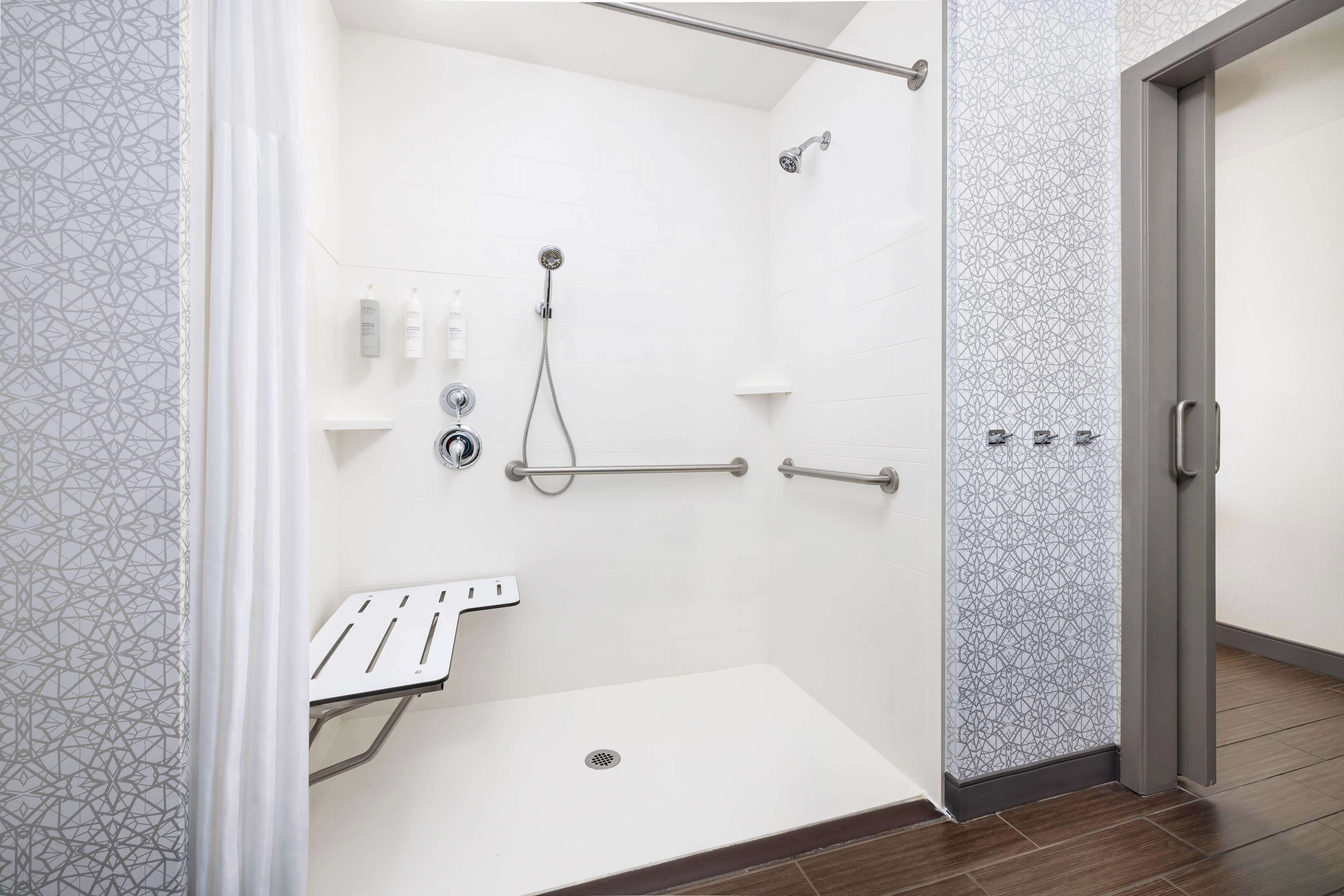 A modern bathroom with a shower, a toilet, and a sink.