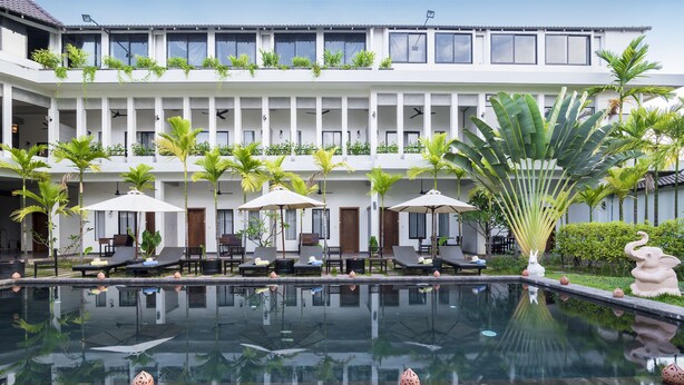 A hotel with a pool, sun loungers, and umbrellas. - Ompil Angkor Residence (Siem Reap)