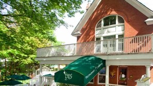 Un bâtiment en briques doté d’un balcon et d’un espace extérieur aménagé pour s’asseoir.