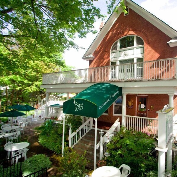 A brick building with a balcony and outdoor seating area.