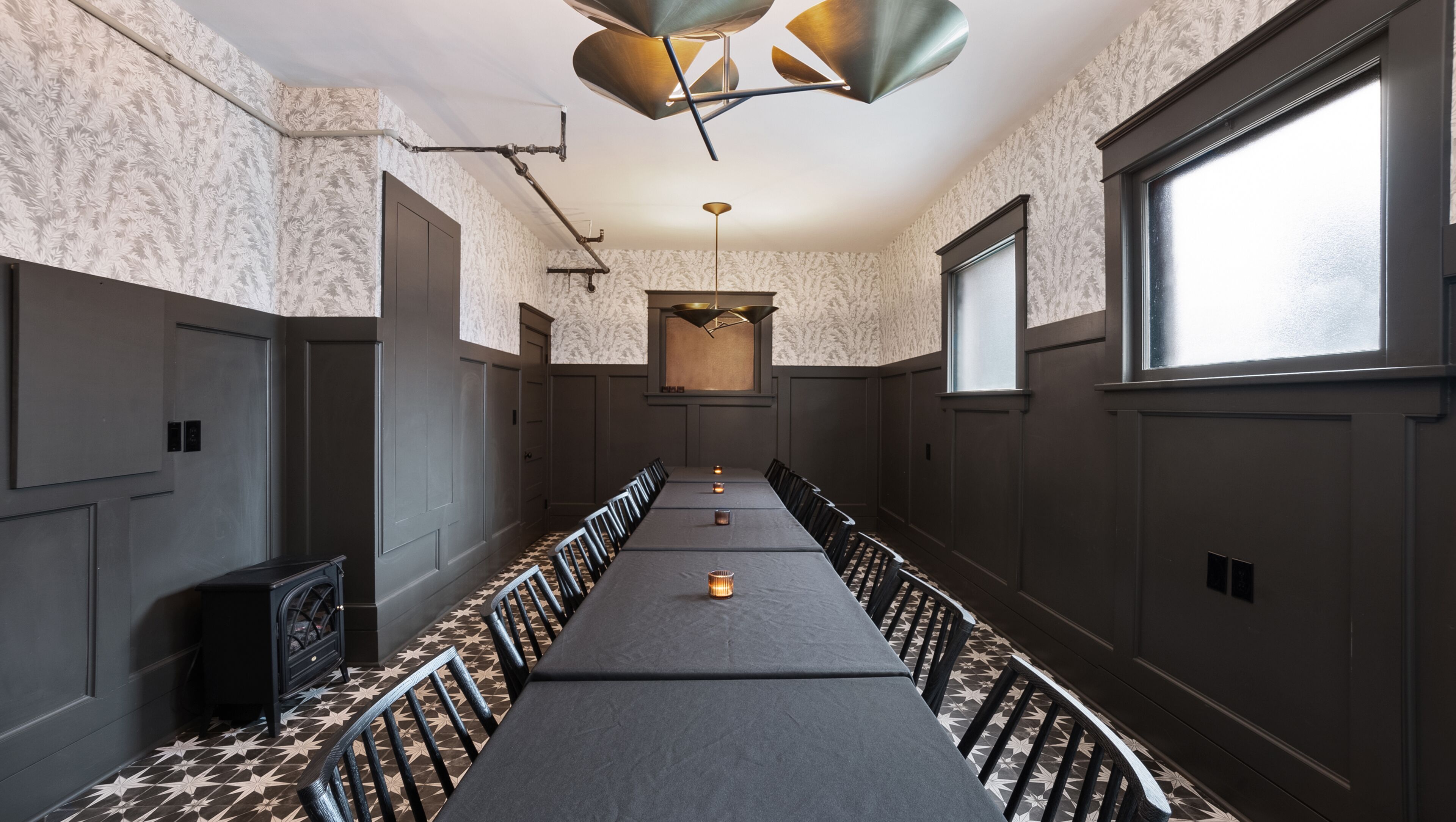 Una sala conferenze ampia con un tavolo scuro, sedie e un pavimento decorato.