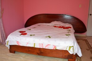 Un lit avec une couvre-lit à motifs floraux et un oreiller orné de roses.