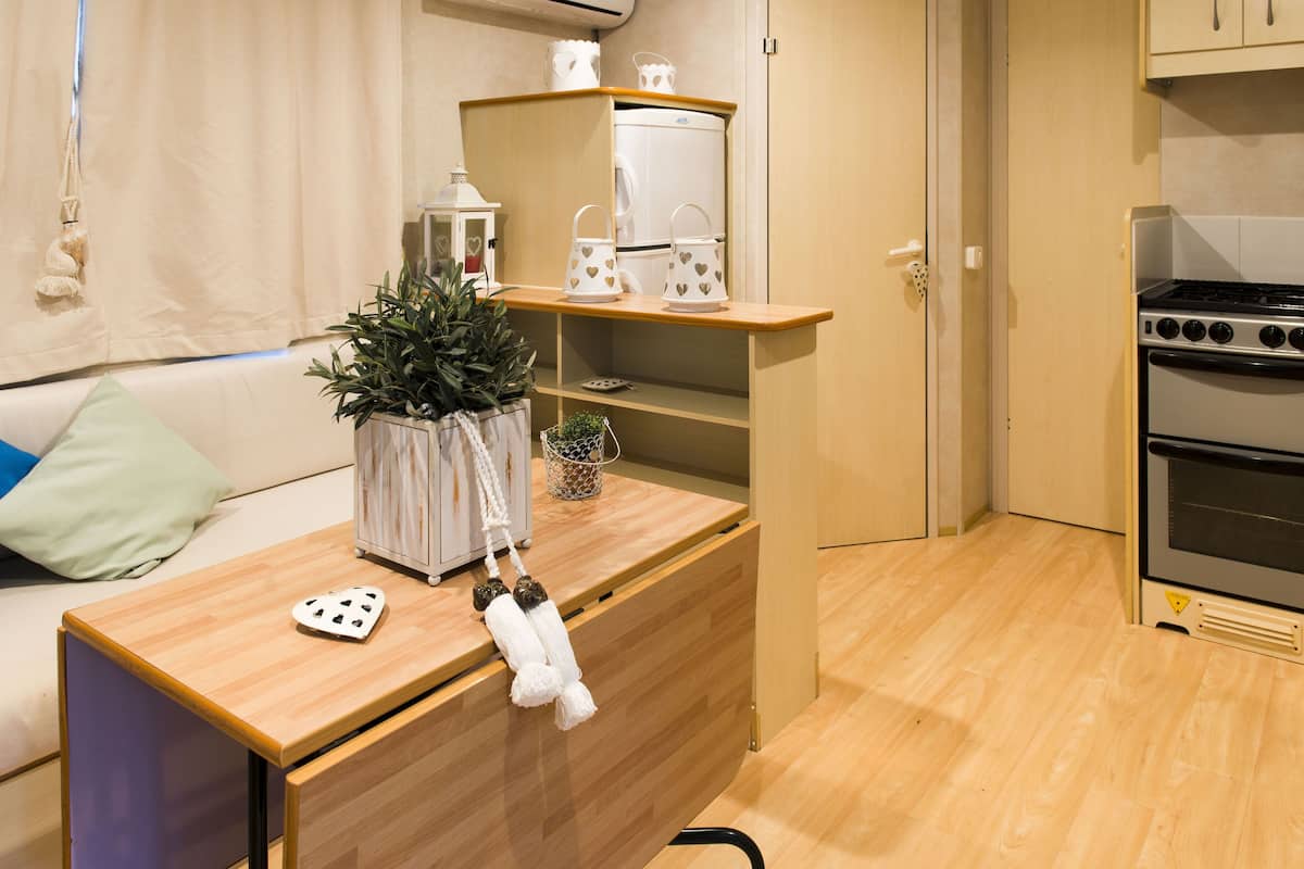 Een kleine keuken met een houten aanrecht, een inbouwoven en een klein spoelbakje.