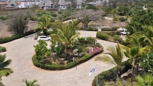 A residential area with houses, a paved driveway, and palm trees. - Watamu Palm Beach (Watamu)