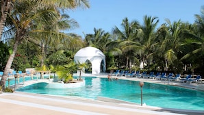 A pool area with lounge chairs, a small bridge, and a gazebo. - Watamu Palm Beach (Watamu)