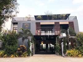Un edificio moderno con un logotipo destacado, un balcón y una entrada con portón.