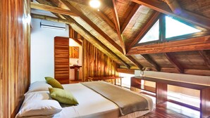 Una habitación de madera con una cama, un banco y vistas al exterior.