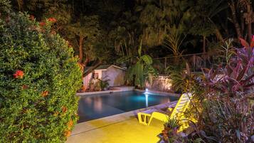 Una piscina al aire libre, sombrillas, tumbonas