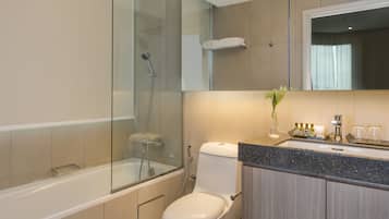 Een moderne badkamer met een douchecabine van glas, een wit toilet en een wastafel met spiegel.